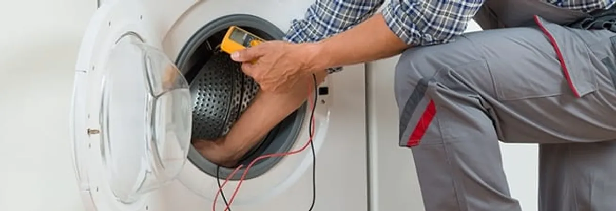 Dryer repair technician inspecting and repairing a clothes dryer in Fargo, ND