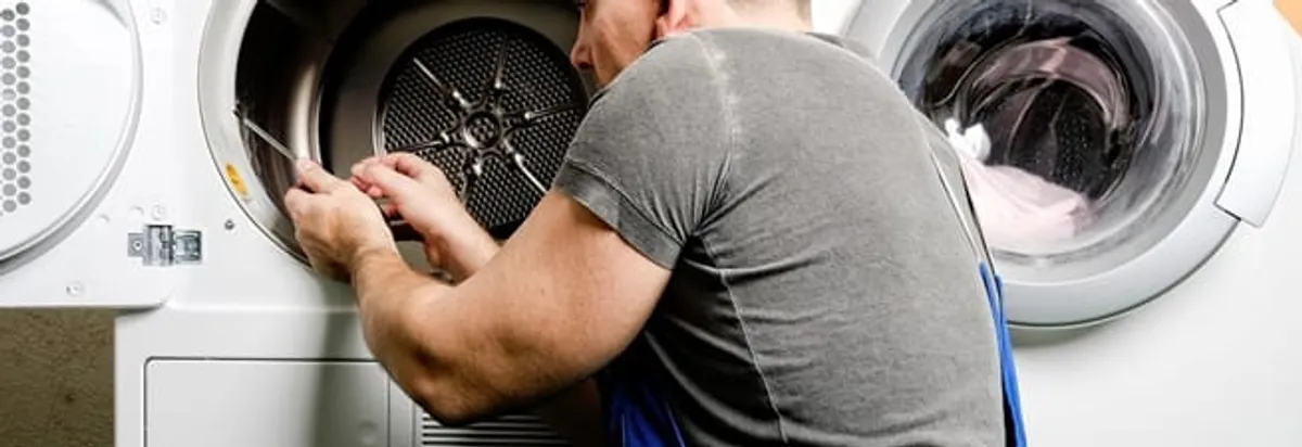 Dryer repair technician fixing a clothes dryer drum in Fargo, ND