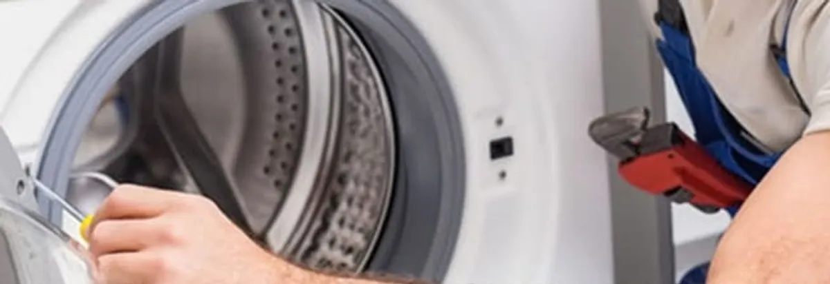 Appliance technician repairing a clothes dryer drum and internal parts in Fargo, ND